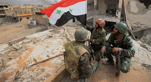soldados izan la bandera siria en Al Qaryatain