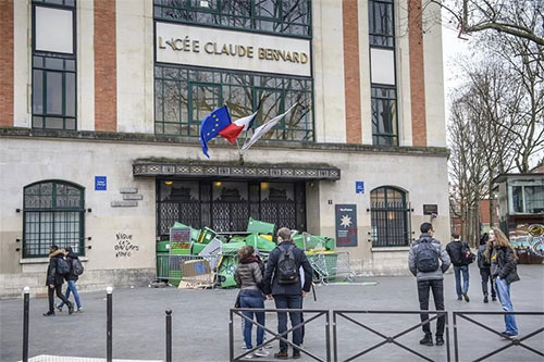 la puerta de un liceo bloqueada por cubos de basura Disturbios en París durante una protesta estudiantil