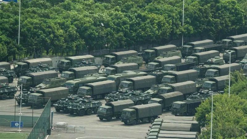 Cientos de veh&iacute;culos militares chinos esperan en un estadio cerca de Hong Kong